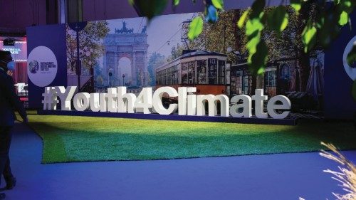 A man walks next to a sign of the Youth4Climate conference in Milan, Italy, September 28, 2021. ...