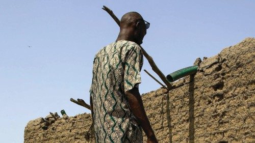 A south Sudanese refugee inspects a house, damaged due to floods, in the al-Qanaa village in Sudan's ...