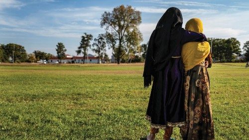 Afghan refugee girls watch a soccer match near where they are staying in the Village at the Fort ...