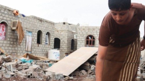 A boy holds shrapnel of a missile at the site of a Houthi missile attack in Marib, Yemen October 3, ...