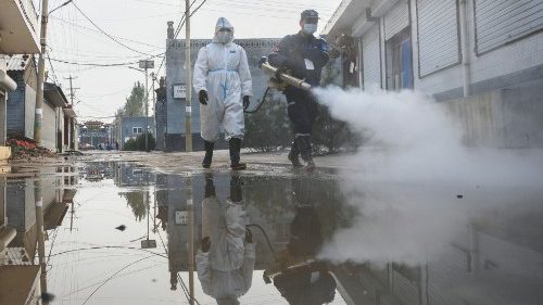 Staff members spray disinfectant after heavy rainfall at a flooded area in Jiexiu in the city of ...