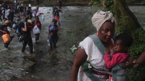 A Haitian migrant woman carries a toddler as she crosses the jungle of the Darien Gap, near Acandi, ...