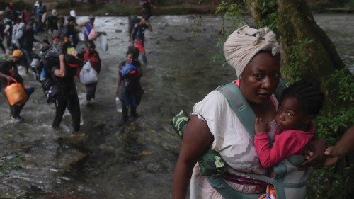 A Haitian migrant woman carries a toddler as she crosses the jungle of the Darien Gap, near Acandi, ... A Haitian migrant woman carries a toddler as she crosses the jungle of the Darien Gap, near Acandi, ...