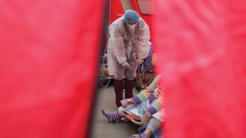 Medical staff assist coronavirus disease (COVID-19) patients in a tent erected next to the emergency ...