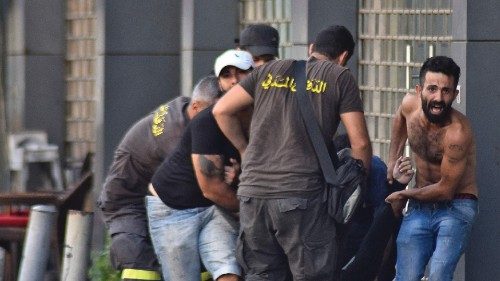 Lebanese civil defence members and others evacuate a fallen person amidst clashes in the area of ...