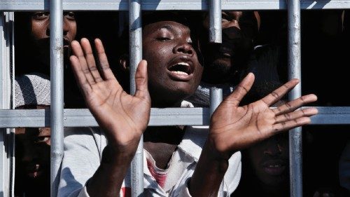 A migrant gestures from behind the bars of a cell at a detention centre in Libya, Tuesday 31 January ...
