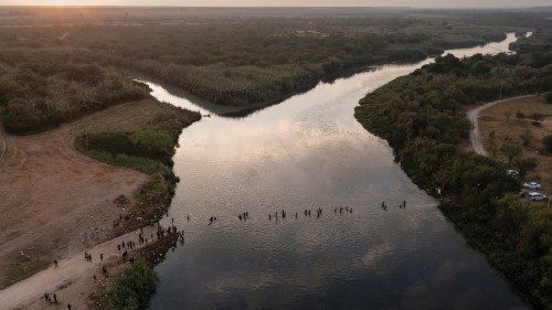 FILE PHOTO: Migrants seeking refuge in United States cross the Rio Grande river, with bags and ...