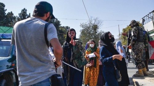 A Taliban members (C) gestures towards journalists covering a women's rights protest in Kabul on ...