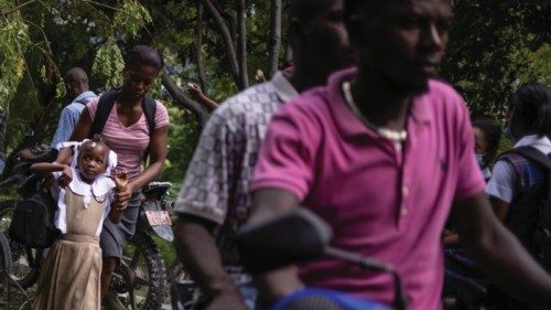 A schoolgirl looks towards police as she walks through a barricade during a protest against fuel ...