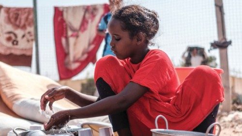 One of the children of Yurub Abdi Jama washes dishes at their home in an informal settlement of ...