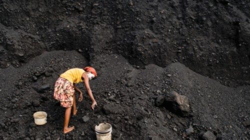 Witbank. All'interno di una miniera di carbone una donna raccoglie del carbone che porterà alla ...