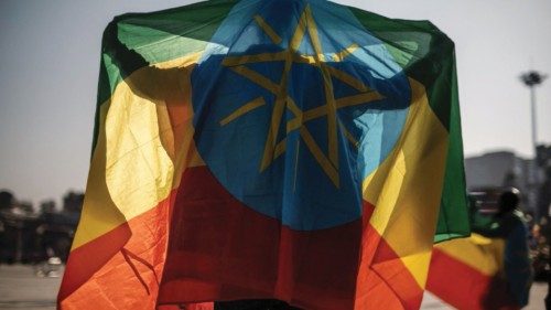 TOPSHOT - A man covers himself with an Ethiopian flag during a rally in Addis Ababa, Ethiopia, on ...