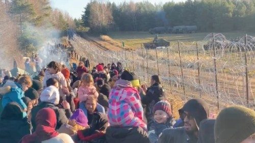 Migrants gather near a barbed wire fence on the Poland - Belarus border in Grodno District, Belarus, ...