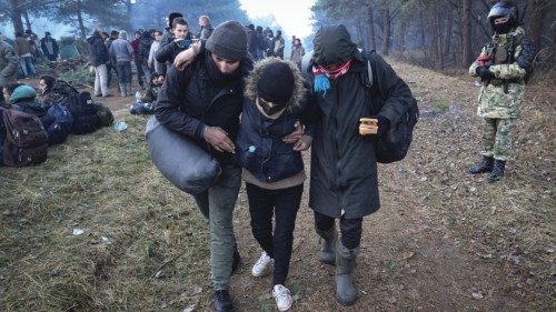 epa09574844 Migrants gather at their camp at the Belarus-Polish border in the Grodno region, ...