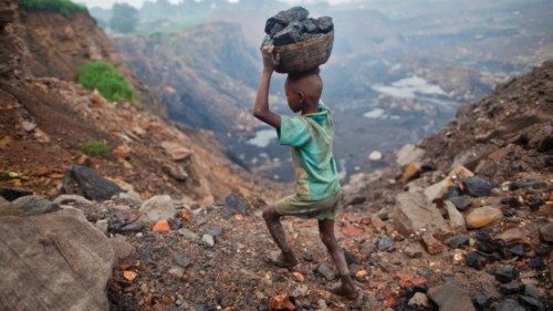 A boy carries coal at an open cast coal field at Dhanbad district in the eastern Indian state of ...