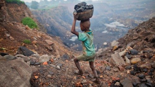 A boy carries coal at an open cast coal field at Dhanbad district in the eastern Indian state of ... A boy carries coal at an open cast coal field at Dhanbad district in the eastern Indian state of ...