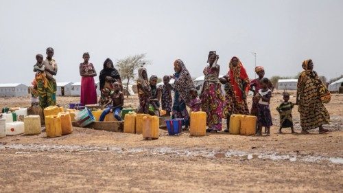 Women queue at the water pump in Goudebou, a camp that welcomes more than 11,000 Malian refugees in ...