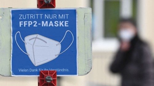 A sign informs people to cover mouth and nose with an FFP2 mask in front of a Covid-19 pandemic test ...