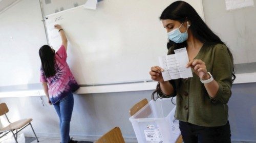 Election workers count votes at a polling station inside a school during presidential and ...