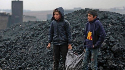 Syrian boys transport coal as they work at a makeshift oil refinery near the Turkish-controlled ...
