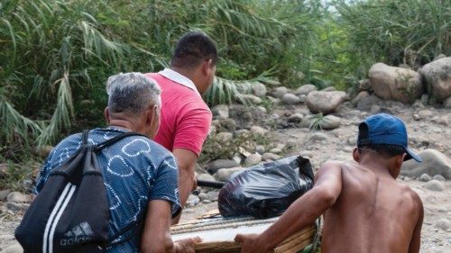 TOPSHOT - Venezuelans push a cart loaded with purchases into Venezuela through the so-called ...