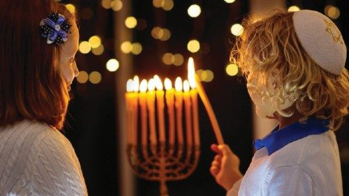 Kids celebrating Hanukkah. Jewish festival of lights. Children lighting candles on traditional ...