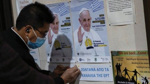 A man hangs posters announcing the visit of Pope Francis in Greece, outside the Catholic Cathedral ...