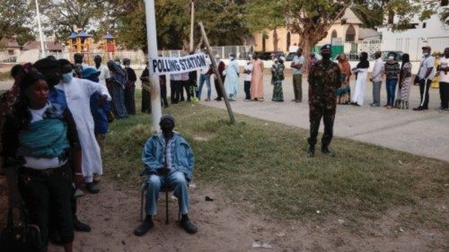 People queue outside a polling station to vote in the Gambian presidential election, in Banjul, ...