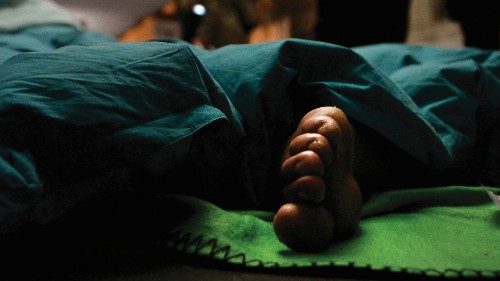 A picture shows the foot of a homless person sleeping outside the Termini train station on November ...