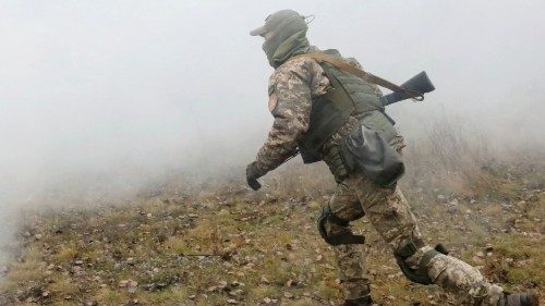 A reservist of the Ukrainian Territorial Defence Forces runs amidst smoke while taking part in ...