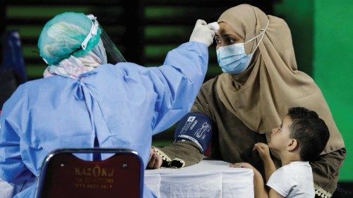 FILE PHOTO: A woman undergoes a health screening before receiving a dose of a vaccine against the ...