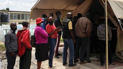 FILE PHOTO: People stand in line to receive a COVID-19 vaccine, at the Narok County Referral ...