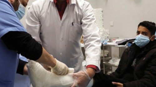 Mohammad Arrad, a Syrian refugee and doctor, attends to a boy at a public hospital in Amman, Jordan ...