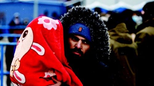 A migrant holds a child at the transport and logistics centre Bruzgi on the Belarusian-Polish ...