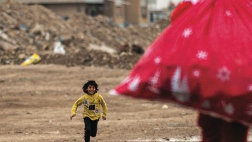 TOPSHOT - A child runs towards Mohamed Maarouf, 28, as he walks with a sack of gifts while dressed ...