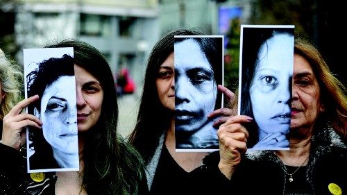 Activists of the 'Declic' movement for women's rights hold printed half face pictures showing ...