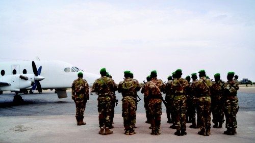 Malian soldiers wait on the tarmac for the arrival of the Chief of Staff before the handover ...
