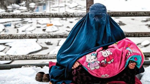 TOPSHOT - A burqa-clad Afghan woman sits with a child on her lap as she seeks alms from passers-by ... TOPSHOT - A burqa-clad Afghan woman sits with a child on her lap as she seeks alms from passers-by ...