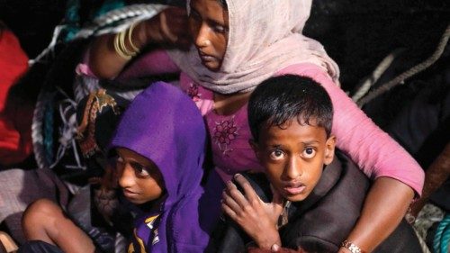 Rohingya refugees sit on a wooden boat as Indonesian official conduct evacuation at the Krueng ...