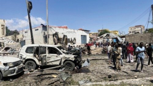 Civilians look at the wrecked vehicles at the scene of an explosion in the Hamarweyne district of ...
