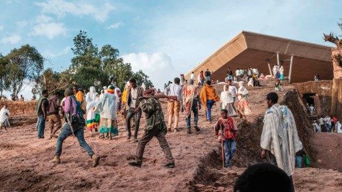 Amhara militia men walk with their rifles among a crowd of pilgrims during the eve of the ...