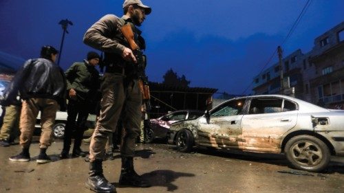 A Syrian fighter stands guard at the scene of an explosion that took place at the popular market of ...