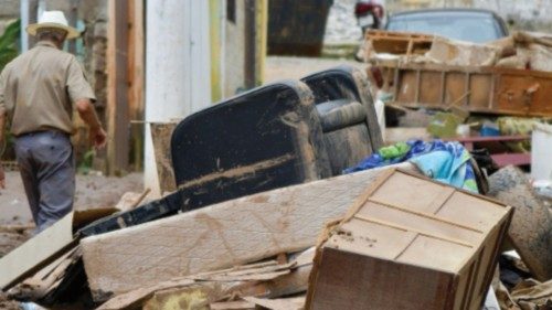 Residents clean the streets after floods hit the area with pouring rains in Raposos, in Minas Gerais ...