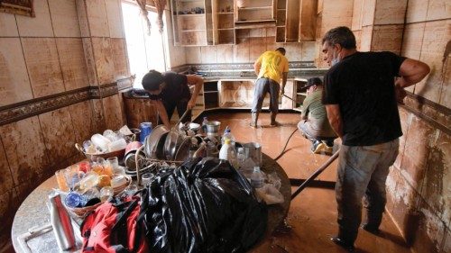 Residents clean their house after floods hit the area with pouring rains in Raposos, in Minas Gerais ...
