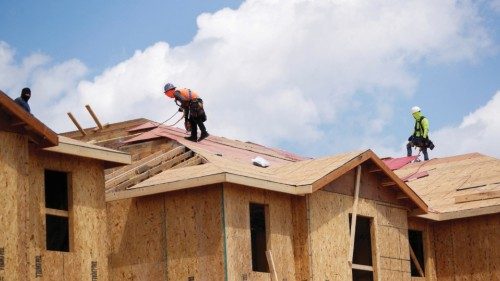 FILE PHOTO: Carpenters work on building new townhomes that are still under construction while ...