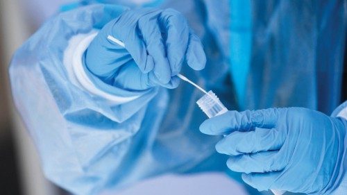 A healthcare worker places a test swab into solution for a PCR Covid-19 test at a Reliant Health ...