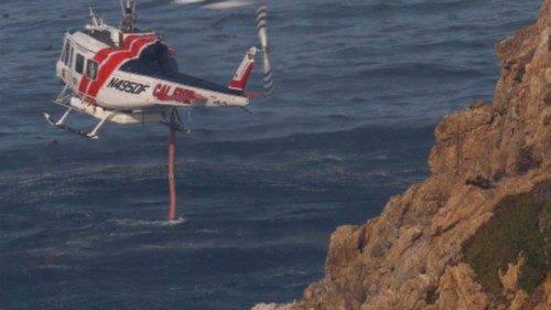 A Cal Fire water dropping helicopter draws water from the Pacific Ocean as the Colorado Fire burns ...