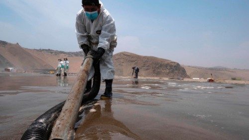 Cleaning crews work to remove oil from the Cavero Beach in Callao, Peru, on January 26, 2022, after ...