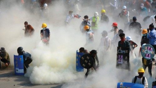 (FILES) In this file photo taken on March 2, 2021, protesters react after tear gas is fired by ...