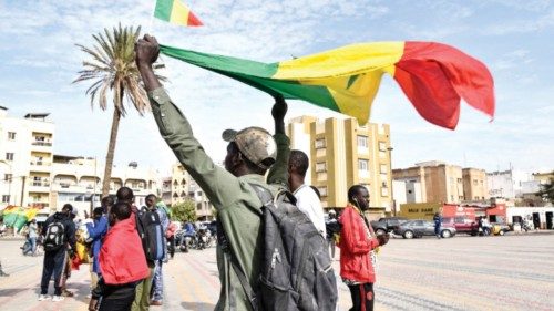 A protester holds a flag of Mali during a demonstration to support Mali on Obelisk Plazza in Dakar, ...